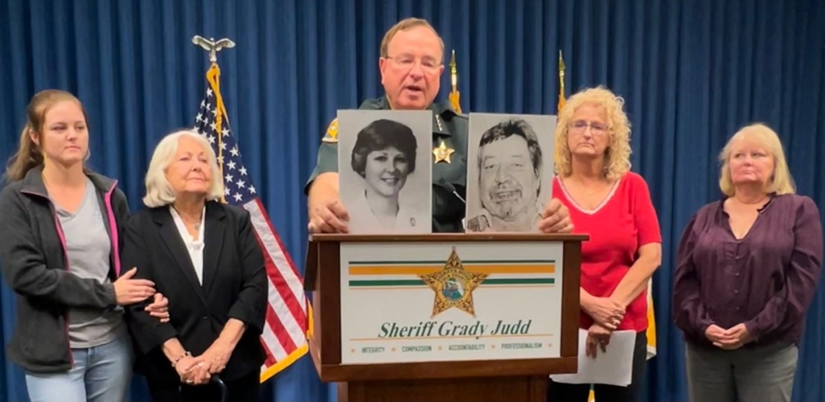 Polk County Sheriff Grady Judd holds up photos of nurse Teresa Scalf and her killer, Donald Douglas. To his left are Teresa Scalf's granddaughter and namesake, Teresa Wooters, mother, Betty Scalf, and sisters Pamela Shade and Lynne Scalf. | Kimberly C. Moore, LkldNow