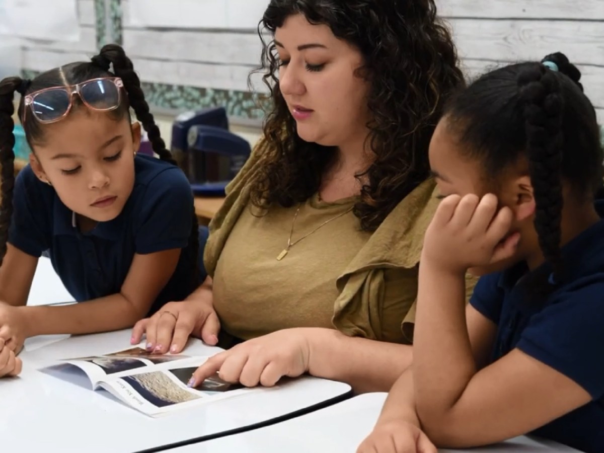 A volunteer reads with children.