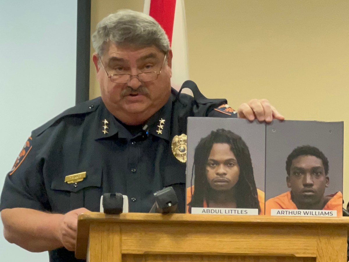 Lakeland Police Chief Sam Taylor holds up the mig shots of two men involved in the attempted murder of two LPD detectives.